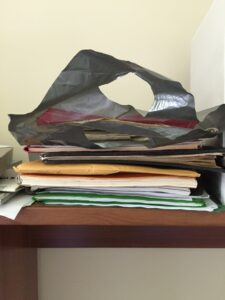 Piles of paper and filed on a desk top.