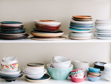 colourful food bowls stacked on two shelves.
