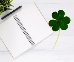 notebook on desk with clover leaf