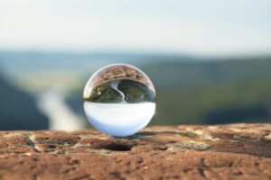 image of valley seen through a crystal ball on a rock ledge