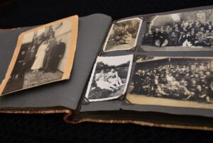 faded and yellowed black and white photographs in photo album.