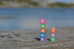 weathered wooden platform with colourful block spelling Thank You. Use gratitude to help get organized.