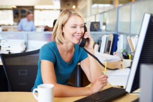 woman in blue shirt making a phone call as if talking to parent about downsizing