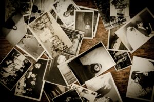 black and white old photos in pile on table