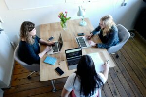 3 women working at a rectangular desk providing each other with accountability